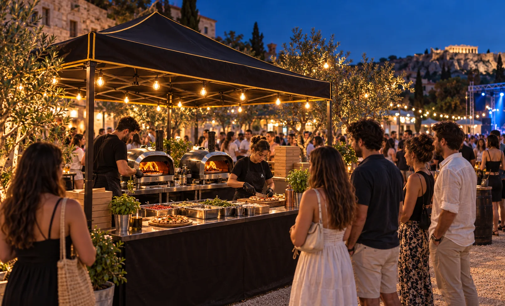 Ενδεικτικό βραδινό pizza pop-up με φωτισμένο πάγκο, φορητά φουρνάκια και κόσμο